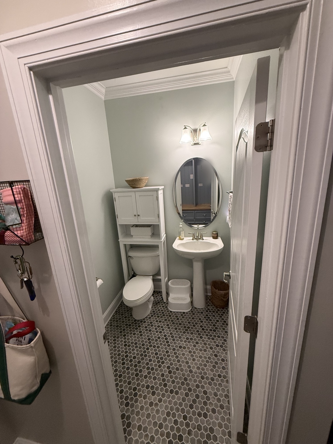 Powder room after with dark hex tile flooring