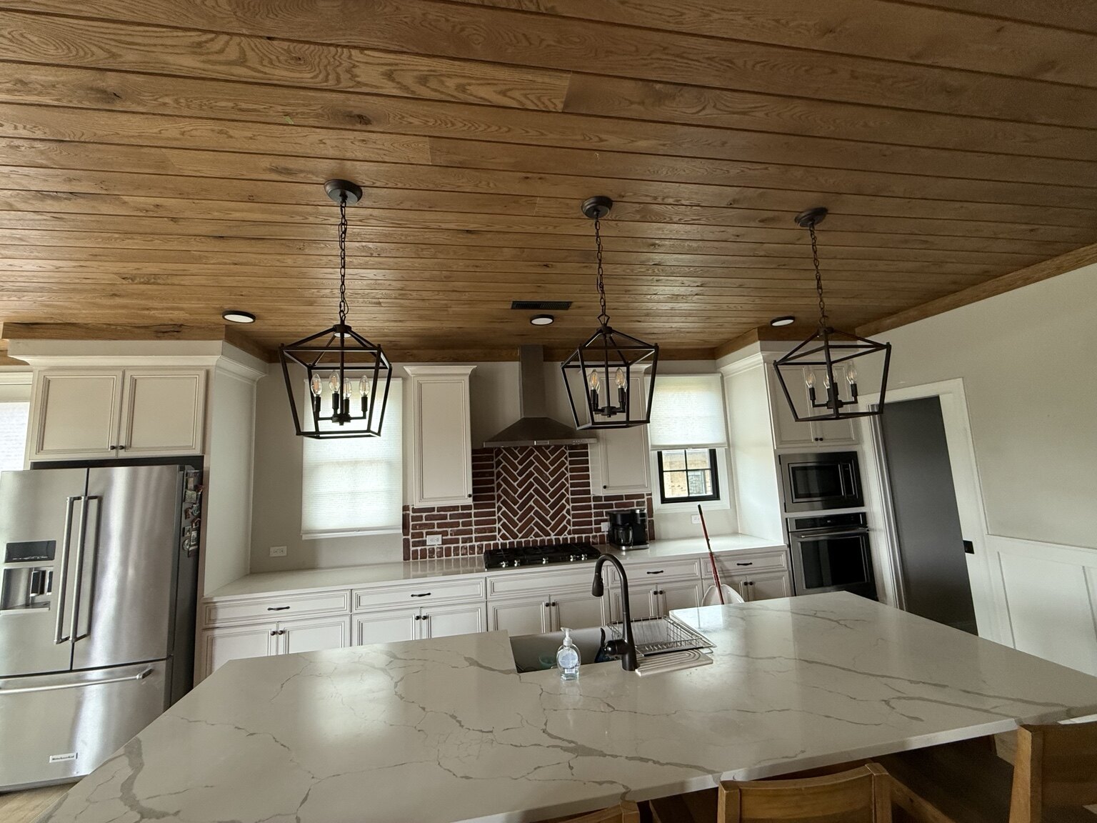 Oak plank ceiling above a finished kitchen